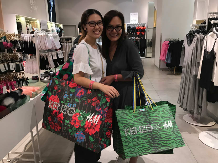 (From left to right:) Student Maria Jessica, 22 and Housewife Sherry Kuhara, 43 with their bags of purchases from Kenzo x H&M collection that adds up to S$2.5k and S$1.3k respectively. Photo: Sonia Yeo