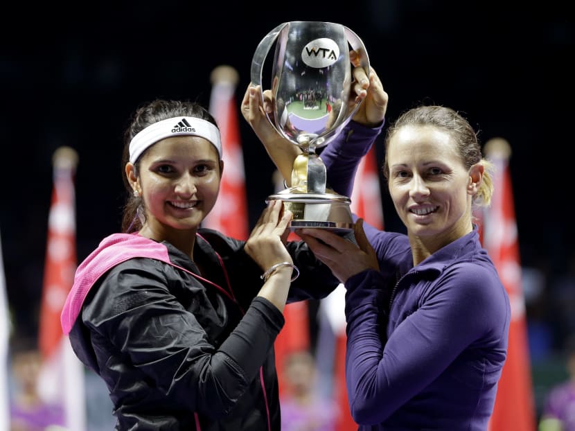 India's Sania Mirza, left, and Zimbabwe's Cara Black hold their trophy aloft after defeating Taiwain's Hsieh Su-Wei and China's Peng Shuai in the doubles final at the WTA tennis finals in Singapore, Sunday, Oct 26, 2014. Photo: AP
