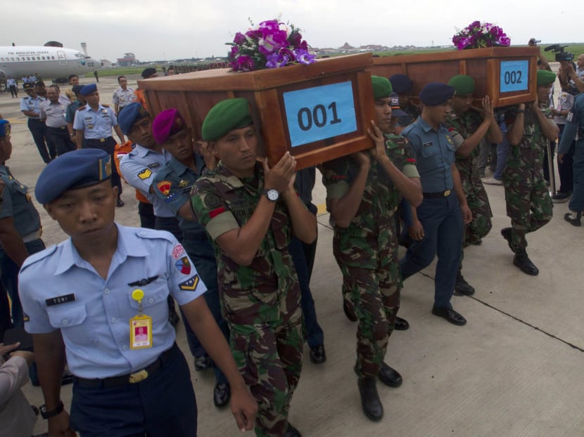 Indonesian military carry the caskets containing the bodies of two AirAsia flight QZ8501 passengers recovered off the coast of Borneo at a military base in Surabaya December 31, 2014. Photo: Reuters