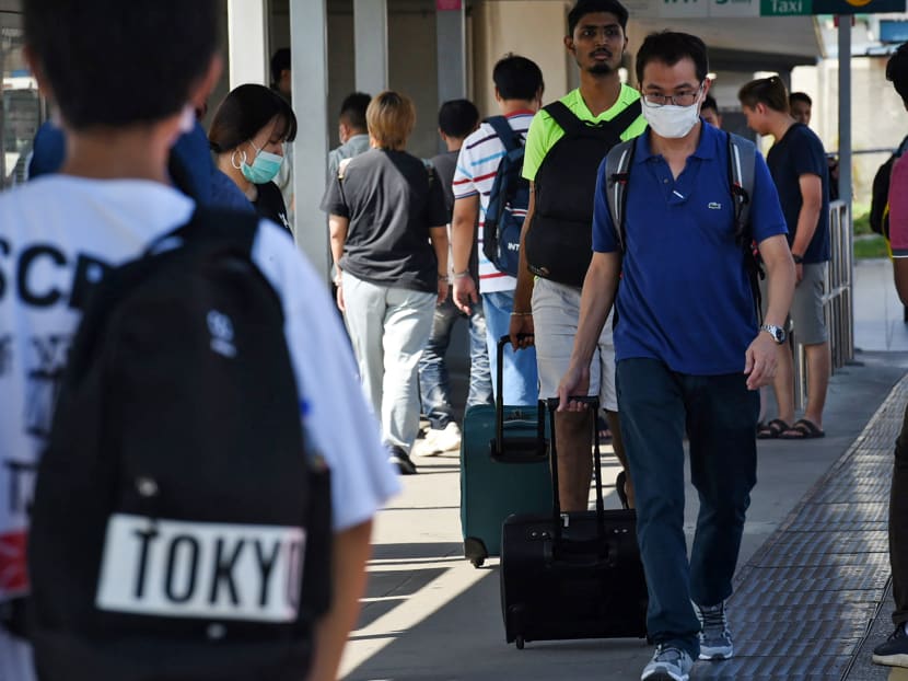 People arriving at Woodlands checkpoint in Singapore on March 17, 2020. Companies who hire Malaysian workers had to scramble to find lodgings for them in Singapore when they cannot return home during Malaysia's lockdown for the rest of March.