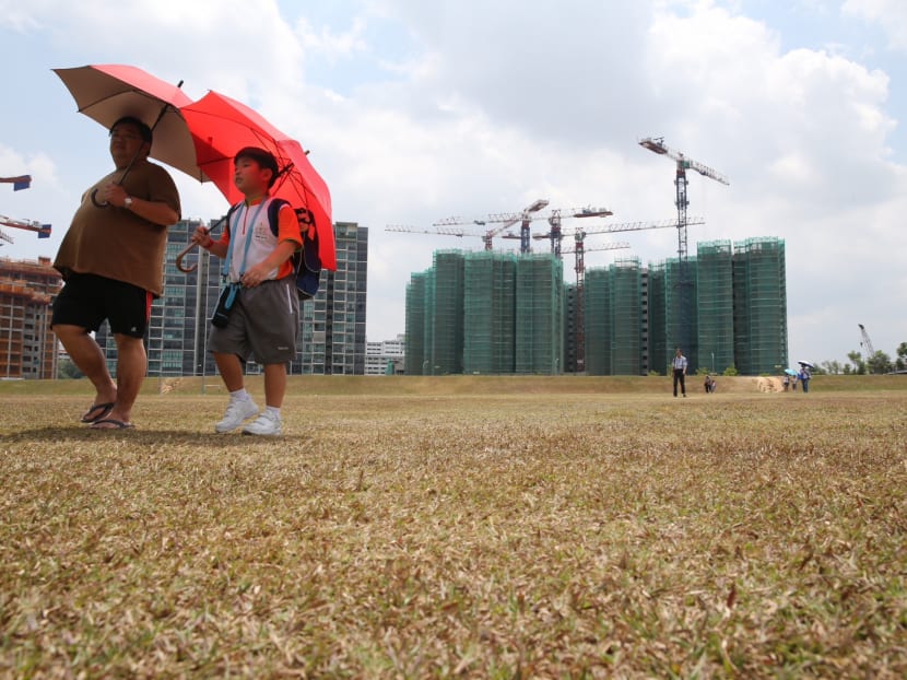 People crossing a parched field outside Buangkok MRT Station. TODAY file photo