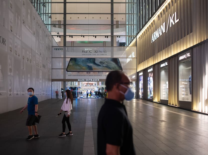 Shoppers wearing facemasks walk in the near-deserted Pavilion shopping mall on the eve of Malaysia's lockdown on travel amid fears over the spread of Covid-19 in Kuala Lumpur on March 17, 2020.
