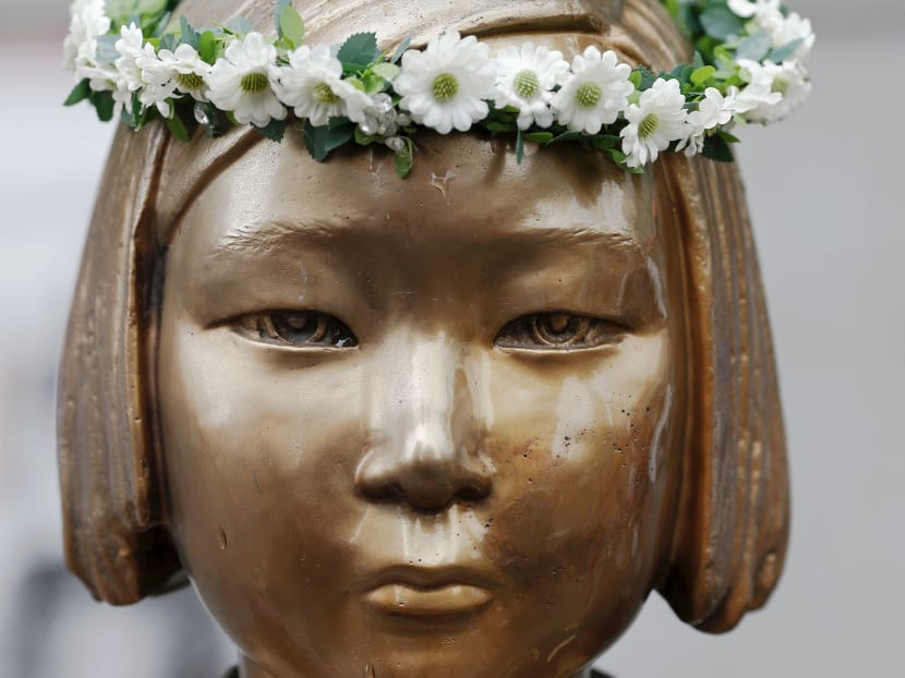 Flowers are placed on a "comfort woman" statue during the weekly Wednesday protest in front of Japanese embassy demanding for an apology and compensation from Japanese government in Seoul, South Korea, July 22, 2015. Photo: Reuters