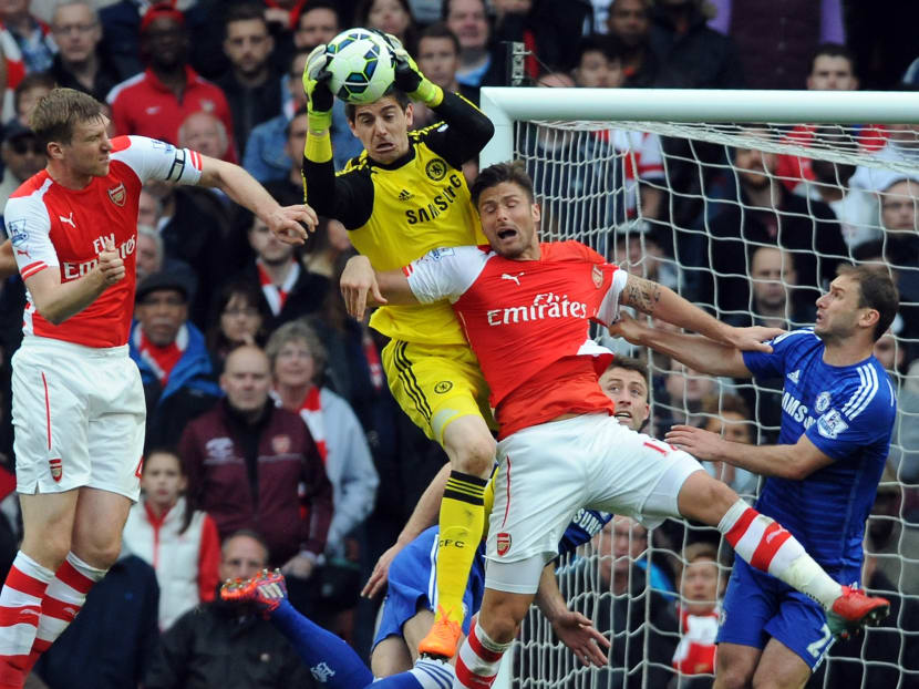 Chelsea goalkeeper Thibaut Courtois, centre, saves from Arsenal's Olivier Giroud, 2nd right, during the English Premier League soccer match between Arsenal and Chelsea at the Emirates Stadium, London, England, Sunday, April 26, 2015. Photo: AP