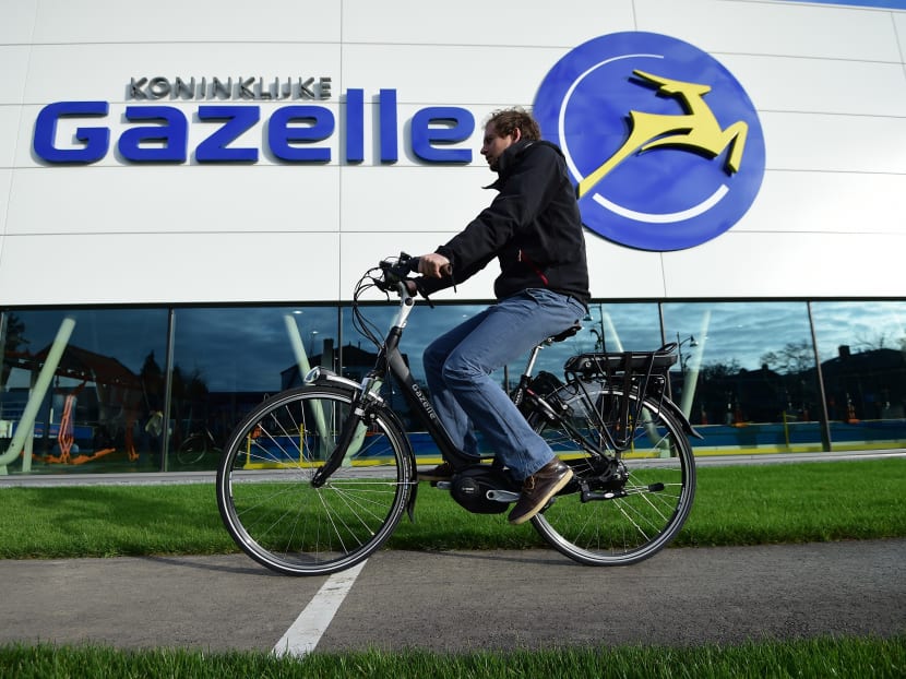 A journalist tests an electric bicycle made by Dutch bicycle manufacturer Gazelle in front of the company's factory in Dieren, the Netherlands. Photo: AFP