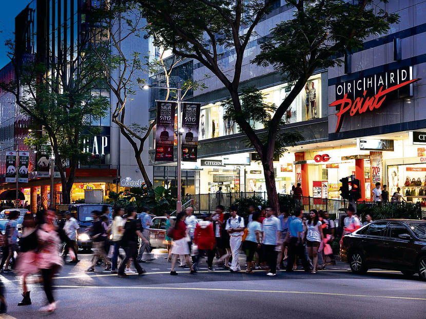 Pedestrians walk across Orchard Road during the evening rush hour in Singapore. Photo: Bloomberg