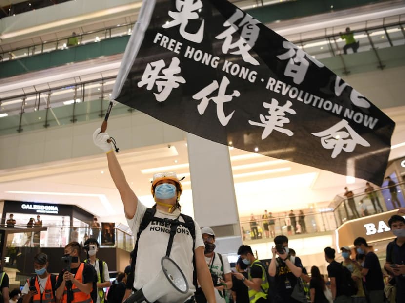 A pro-democracy protester waves a banner during a protest at the New Town Plaza mall in Sha Tin in Hong Kong, China on June 12, 2020.