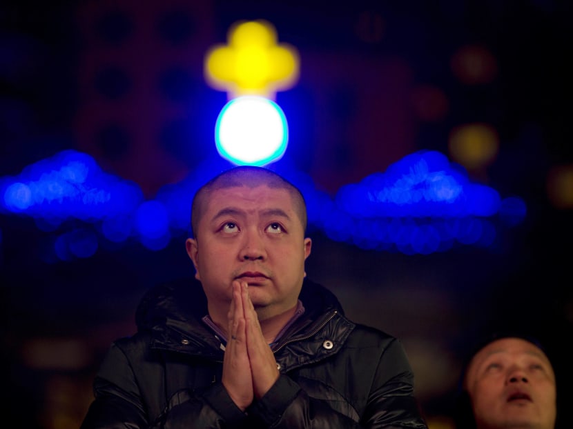 A Chinese man prays during a mass on the eve of Christmas at the South Cathedral official Catholic church in Beijing. Photo: AP