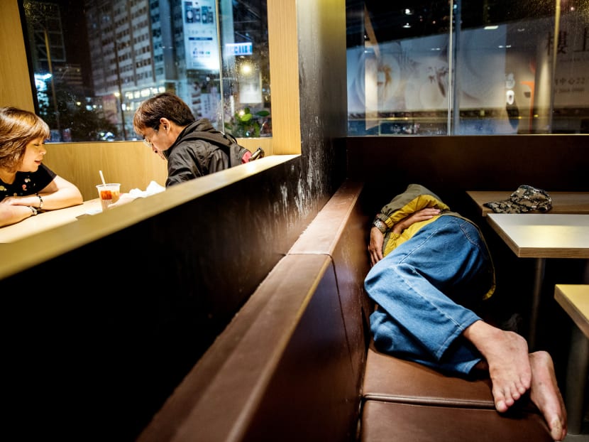 A couple sitting down for a meal as a man sleeps on a seat at a McDonald’s outlet in the Kowloon district of Hong Kong. In a sign of increasing desperation, some of the city’s poor are now turning to 24-hour fast-food restaurants for shelter. Photo: AFP