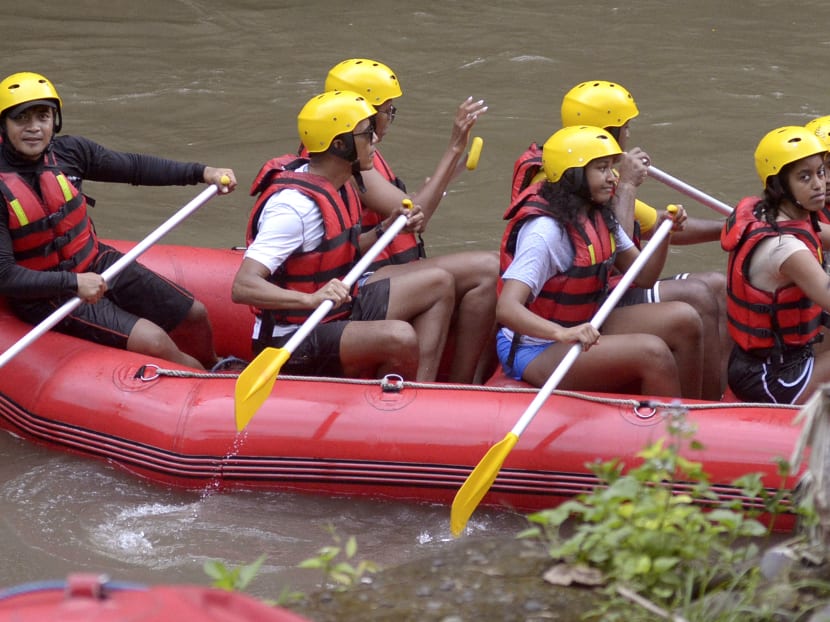 Former U.S. President Barack Obama, center, his wife Michelle, center rear, and daughters Malia, right, and Sasha, second right, raft on Ayung River in Badung, Bali island, Indonesia. Photo: AP