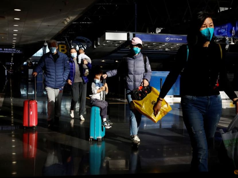 FILE PHOTO: Travellers walk with their luggage at Beijing Capital International Airport, amid the coronavirus disease (COVID-19) outbreak in Beijing, China December 27, 2022. REUTERS/Tingshu Wang