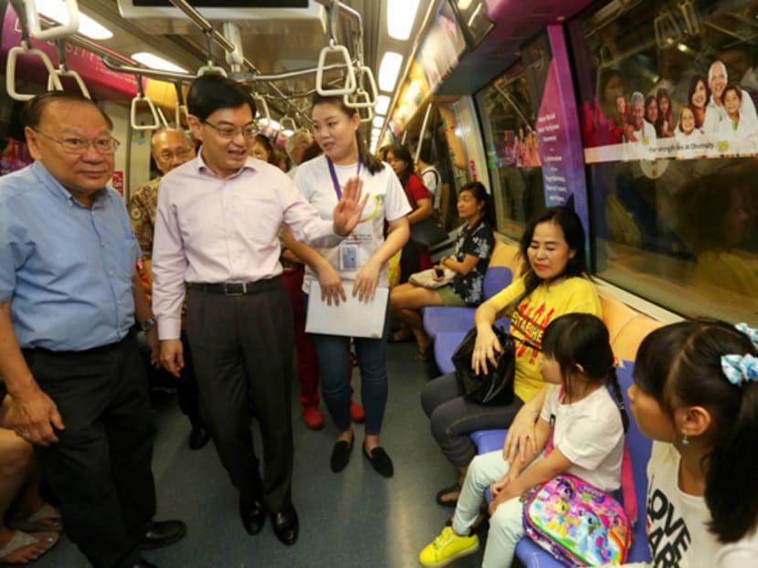 Minister Heng Swee Keat and Lee Kim Siang (left), Chairman of Thye Hua Kwan Moral Society, greet commuters on board the a Harmony-concept train on June 26, 2017. The train is a joint collaboration by the Thye Hua Kwan Moral Society and the National Youth Council. Photo: Nuria Ling/TODAY