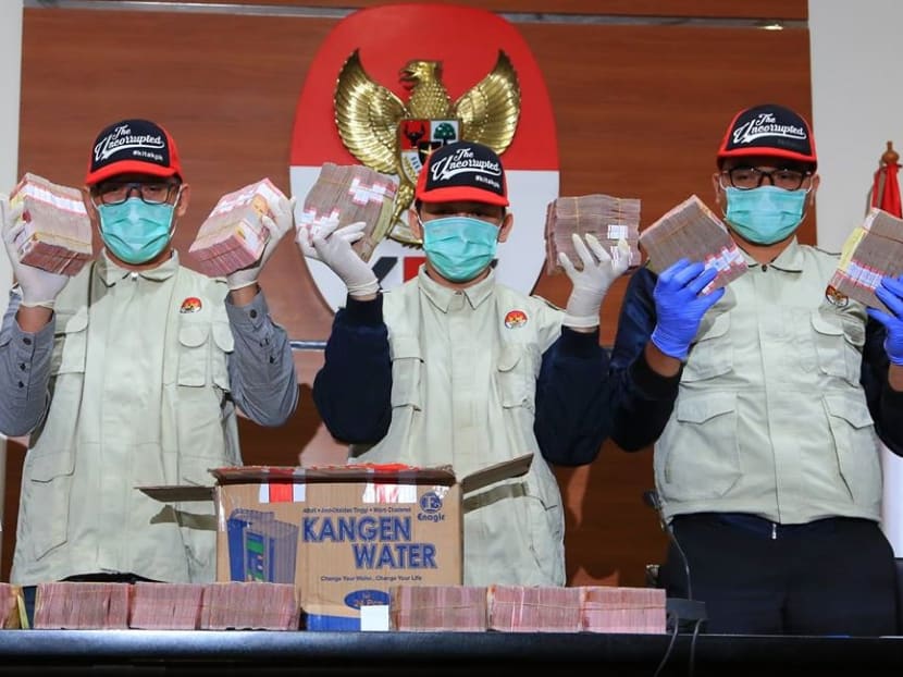 KPK officials showing the 1.28 billion rupiah (S$125,620) placed in a mineral water box that it seized in an investigation in January 2019 into a case allegedly involving kickbacks for infrastructure construction projects. KPK officials showing the 1.28 billion rupiah (S$125,620) placed in a mineral water box that it seized in an investigation in January 2019 into a case allegedly involving kickbacks for infrastructure construction projects.