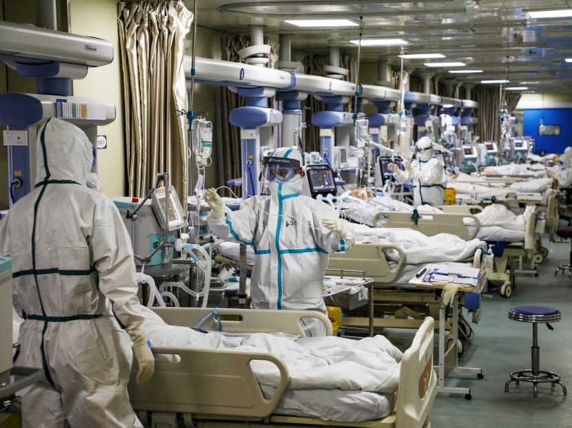 Medical workers in protective suits tend to coronavirus patients at the intensive care unit of a hospital in Wuhan, China.