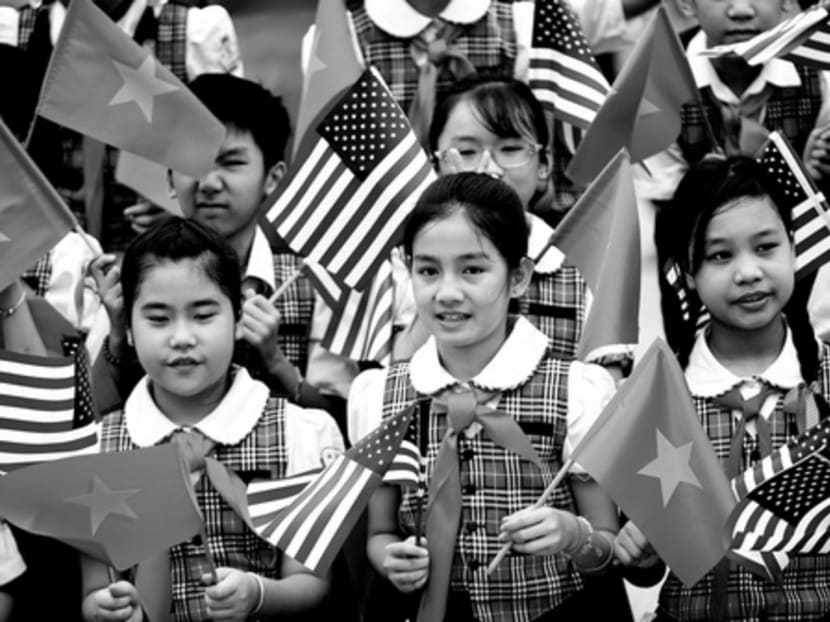 Vietnamese students holding American and Vietnamese flags at a welcome ceremony for President Barack Obama on Monday. Photo: AP