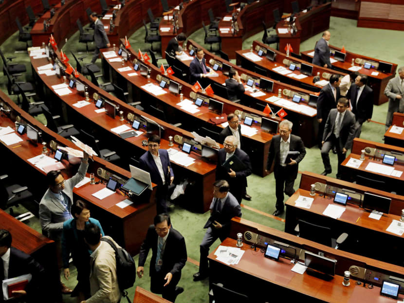Pro-Beijing lawmakers staging a walkout yesterday before the swearing-in of two pro-independence activists, depriving the legislative chamber of the quorum needed to continue the meeting. Photo: AP