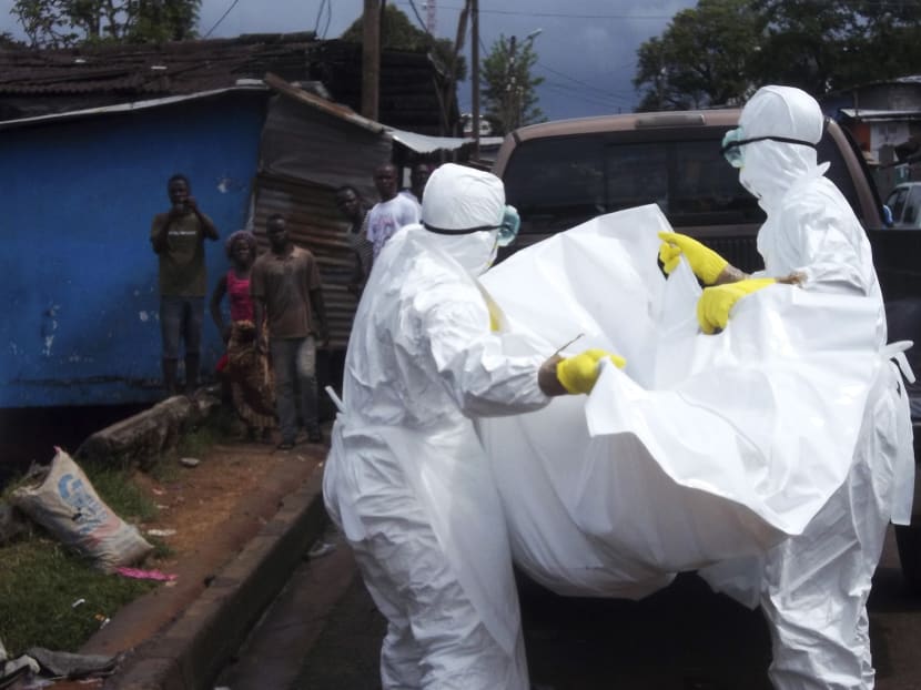 Health workers remove the body of a man believed to have died from the Ebola virus at a street in Monrovia, Liberia, Oct 27, 2014. Photo: Reuters