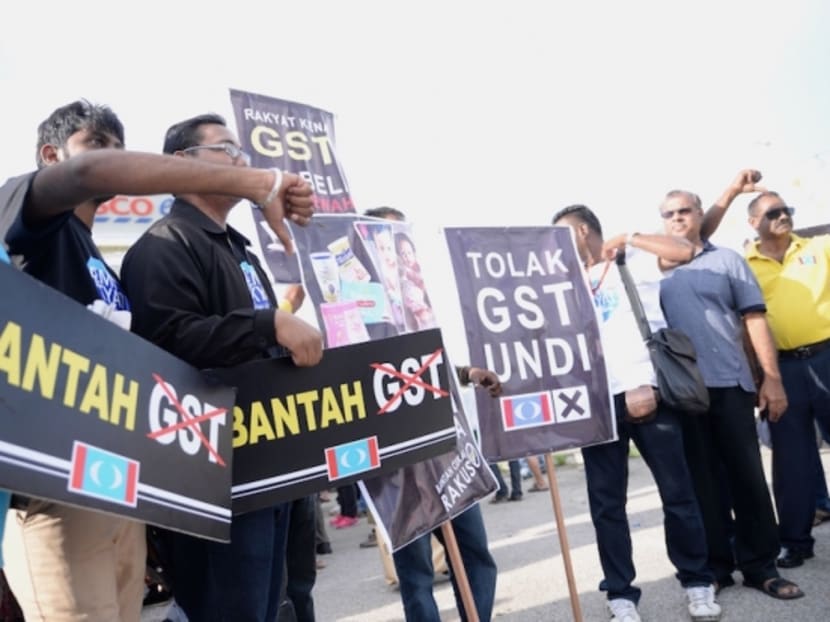 Protesters hold signs and gesture during an anti-GST rally in Seberang Jaya May 1, 2015. Photo: The Malay Mail Online