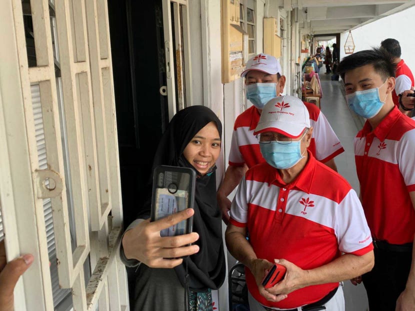 PSP chief Tan Cheng Bock (second from right) with candidates for Chua Chu Kang GRC Choo Shaun Ming and Francis Yuen taking a selfie with a resident at Blk 9 Teck Whye Lane, July 3, 2020.