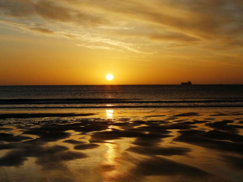 A ship passes across the horizon of the North Sea near Tynemouth beach, North Tyneside, England at sunrise, April 19, 2016. Photo: PA via AP