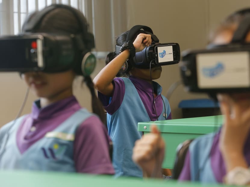 Students wear virtual reality goggles in class, as part of their VR lesson, exploring locations such as fish farms and even factories. Photo: Najeer Yusof/TODAY