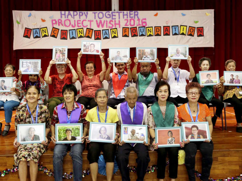 Elderly from Care Community Services Society posing with their professional portraits. Mdm Soon Chain Sun (front row, second from right), 66, had her photos taken as she did not find it pantang (a taboo). She said: 'Everyone has to walk this path; there's nothing to be afraid of.' Photo: Wee Teck Hian