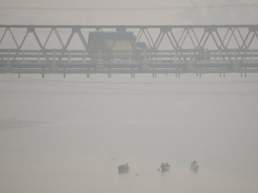 Vehicles drives along Muara Tembesi bridge as haze shrouds in Jambi, October 16, 2015. Photo: Antara Foto via Reuters