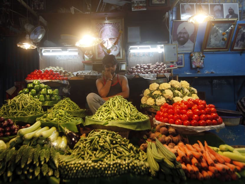 A vegetable vendor sits at his shop in Mumbai, India, Sept 3, 2013. Photo: AP