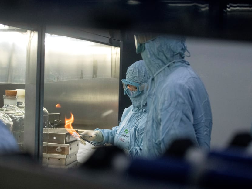 Researchers in protective suits work in a lab at the Yisheng Biopharma company, where researchers are trying to develop a vaccine for the Covid-19 coronavirus, in Shenyang, in China’s northeast Liaoning province, on June 9, 2020.