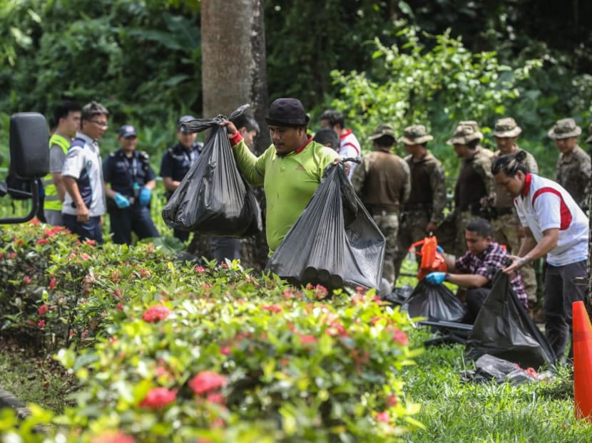 Police and workers fill trash bags with items retrieved from inside a drain along a footpath on Hume Avenue on May 25, 2023. More than 30 bags were seen filled and loaded into a waste management vehicle. 