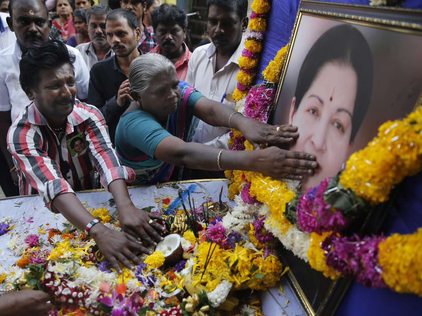 Supporters of India's Tamil Nadu state Chief Minister Jayaram Jayalalithaa pay tributes near her photograph outside their party office in Mumbai, India,in this Dec 6, 2016 file photo. Photo: AP