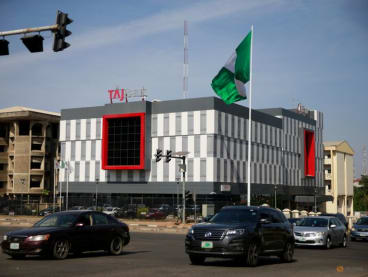 FILE PHOTO: A Nigerian flag is seen in front of a bank in Abuja, Nigeria December 1, 2021. REUTERS/Afolabi Sotunde