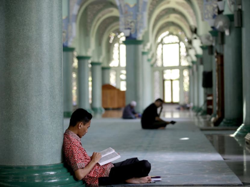 A Muslim man reads the Quran during the first day of the fasting month of Ramadan at a Mosque on the outskirts of Jakarta, Indonesia, Thursday, June 18,2015.Photo: AP