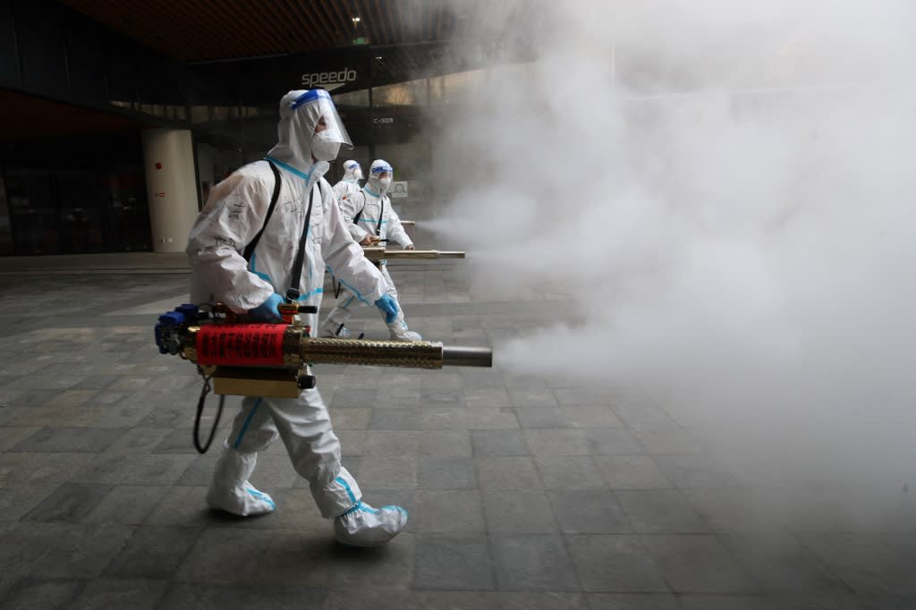 Staff members wearing personal protective equipment spray disinfectant outside a shopping mall in Xi'an in north China's Shaanxi province on Jan 11, 2022.<br />
Staff members wearing personal protective equipment spray disinfectant outside a shopping mall in Xi'an in north China's Shaanxi province on Jan 11, 2022.<br />
