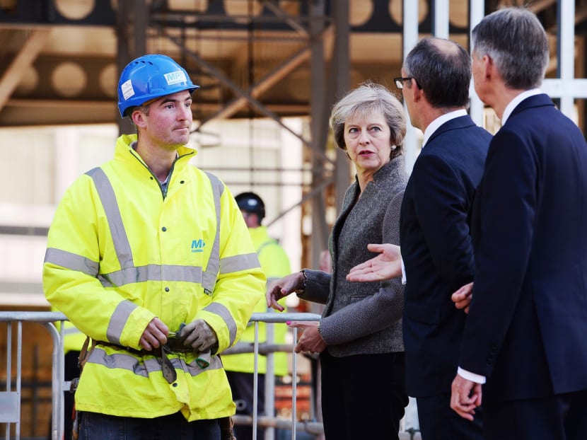 Britain’s Prime Minister Theresa May during a visit to a construction site in Birmingham, England, yesterday, where new HSBC bank offices are being built. Treasury chief Philip Hammond warned of turbulence in the coming years as Britain negotiates its exit from the European Union trading bloc. PHOTO: AP