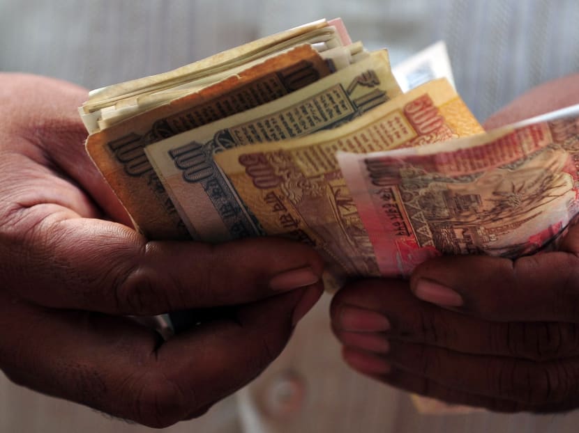A man counting Indian rupees. AFP file photo