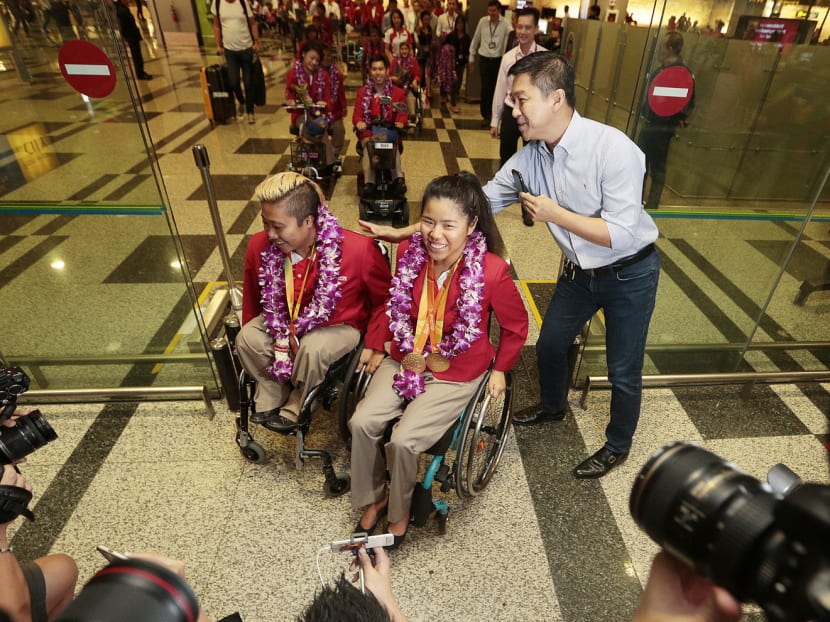 Paralympians Theresa Goh (left) and Yip Pin Xiu being greeted by Minister for Social and Family Development Tan Chuan-Jin at Changi Airport yesterday. Goh bagged a bronze while Yip brought home two golds from the Rio Paralympics. Photo: Jason Quah