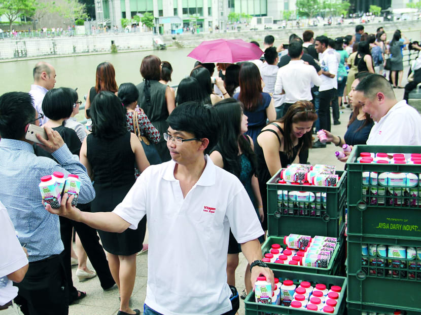 Marigold staff giving out some 7,500 bottles of cold drinks for free to members of the public queuing to pay their final respects to the late Mr Lee Kuan Yew, in front of the Asian Civilisations Museum near Cavenagh Bridge. Photo: Robin Choo