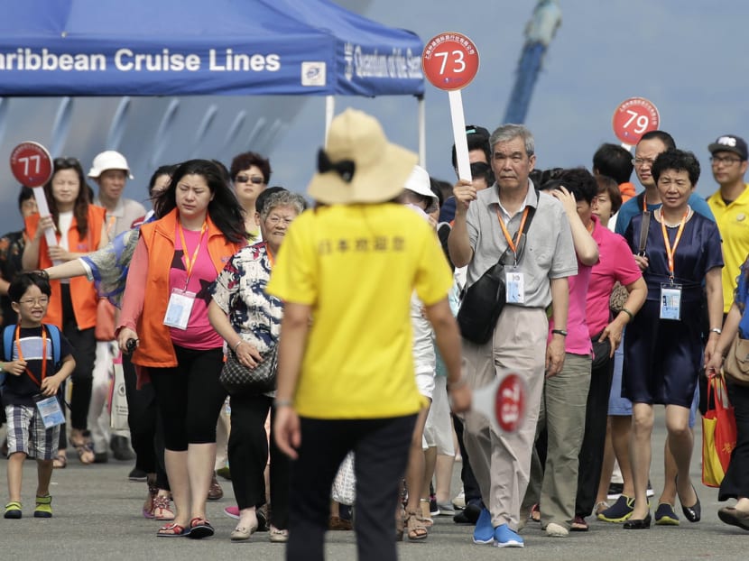 Chinese tourists walk along a pier after disembarking the Quantum of the Seas cruise ship. Japan attracted 19.7 million tourists in 2015 who spent 3.5 trillion yen (S$42.6 billion). Photo: Bloomberg