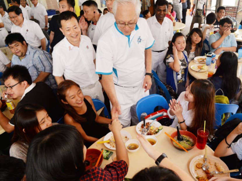 Mr Goh Chok Tong and Mr Victor Lye greeting teenagers at a coffee shop in Hougang Central on Sept 6, 2015. Photo: Robin Choo