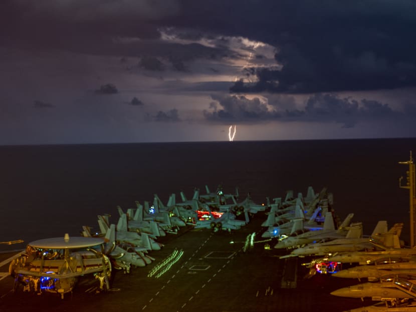 Hand out photo dated July 4 2020 of lightning flashes over US aircraft carrier USS Nimitz as it transits the South China Sea along with another aircraft carrier USS Ronald Reagan. It marked the first time two US aircraft carriers have operated together there since 2014.