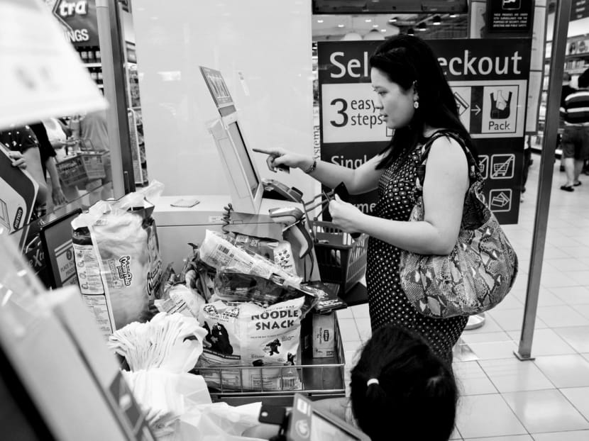 A woman checking out her groceries on her own at a self-checkout machines at Fairprice Xtra at NEX shopping mall on Nov 8, 2015. Photo: Jason Quah/TODAY