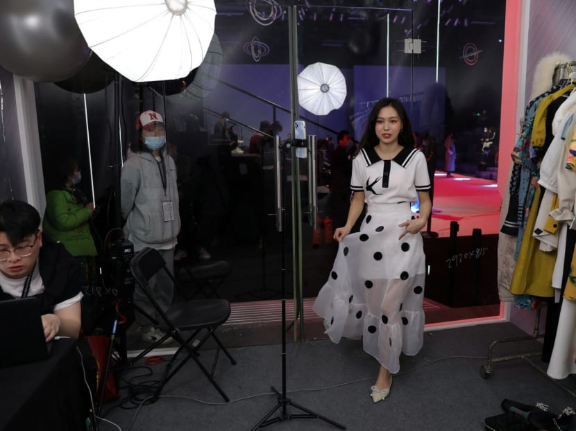 A livestreamer promotes a dress by Xunruo during a live streaming session, inside a booth set up at a show venue during China Fashion Week, in Beijing, China on March 31, 2021. A livestreamer promotes a dress by Xunruo during a live streaming session, inside a booth set up at a show venue during China Fashion Week, in Beijing, China on March 31, 2021.