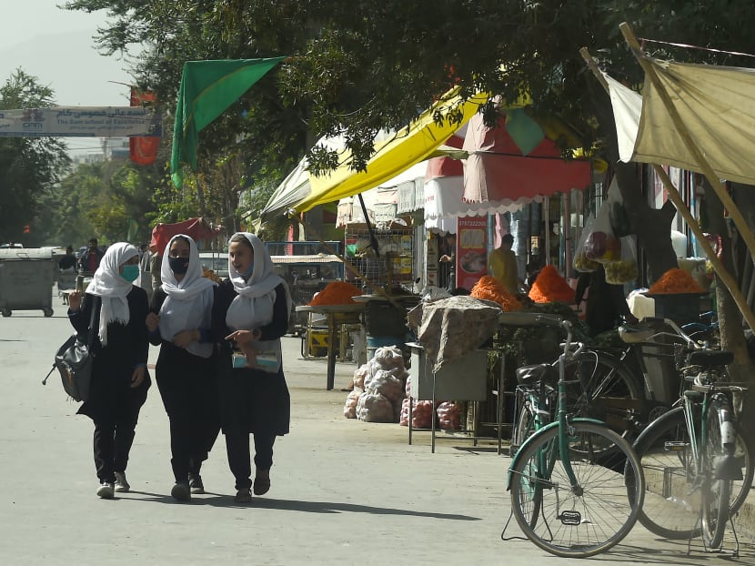 Afghan school girls walking through a street in Kabul on Aug 15, 2021.