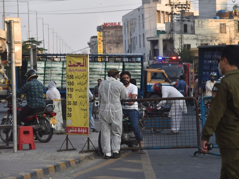 Pakistani policemen block a road duering a government-imposed nationwide lockdown as a preventive measure against the spread of the Covid-19 coronavirus in Lahore on Sunday, April 26, 2020.