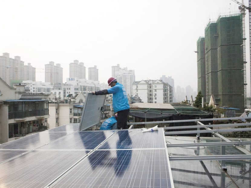 Workers for Wuhan Guangsheng Photovoltaic Co install solar panels on a roof in Wuhan, China. China is home to two-thirds of the world’s solar-production capacity and buys half of the world’s new solar panels. PHOTO: The New York Times