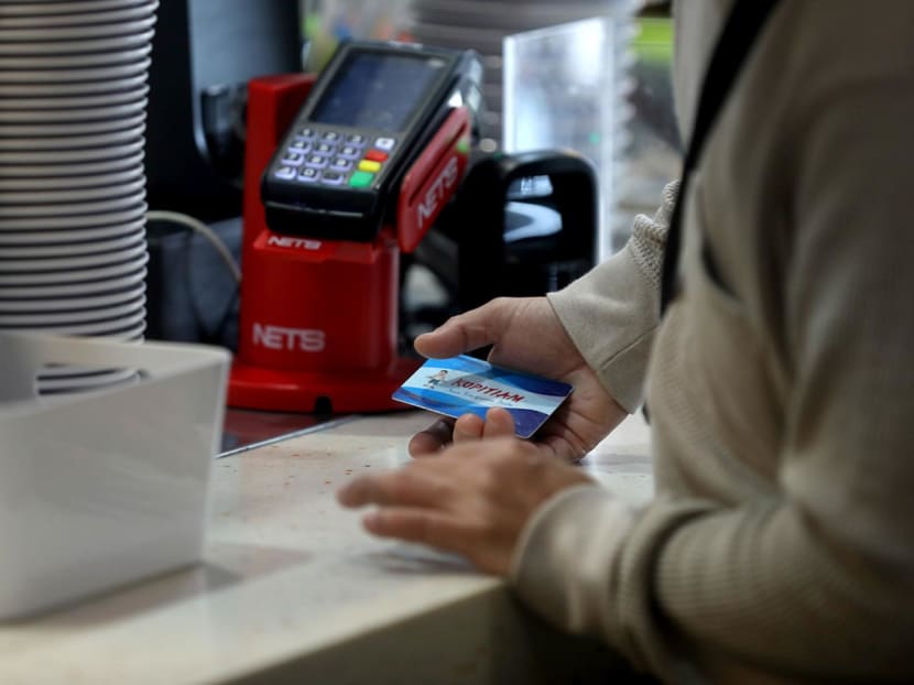 A customer using the Kopitiam card at an outlet in Yew Tee.