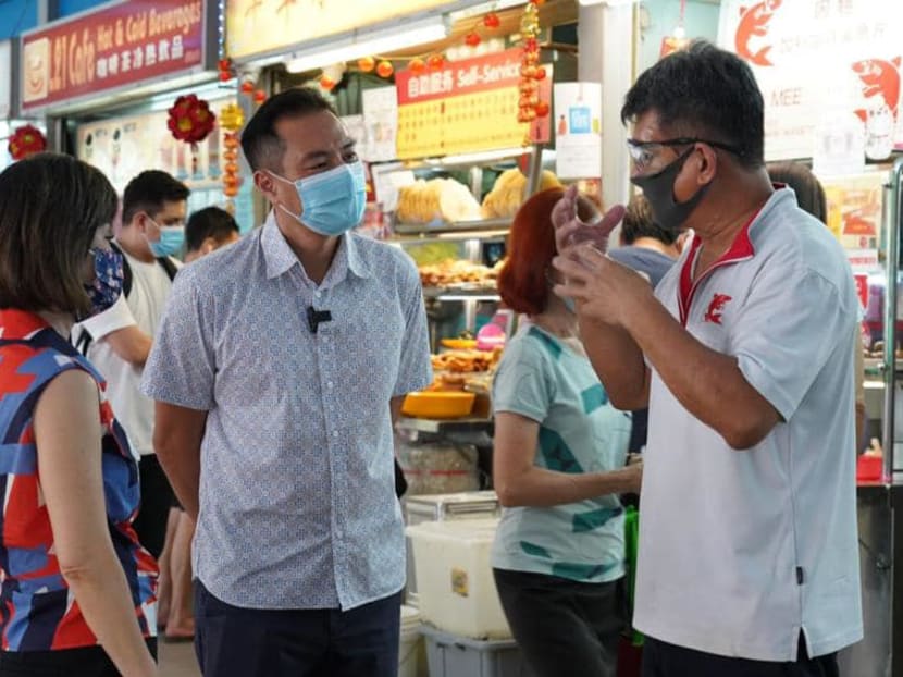 Dr Amy Khor (left), Minister of State for Sustainability and Environment, and Mr Tan Kiat How (centre), Minister of State for Communications and Information, speaking to a hawker at the Tiong Bahru Market and Food Centre.