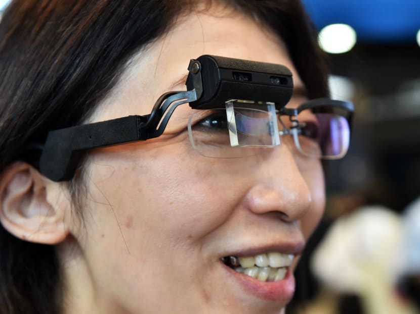 Japanese electronics maker Konica Minolta employee displays a prototype model of a smart glass "Wearable Communicator" at the Combined Exhibition of Advanced Technologies electronics trade show in Chiba, suburban Tokyo on Oct 7, 2014.