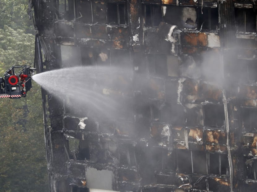 A remote firefighting platform continue to damp-down the deadly fire at Grenfell Tower in London, Thursday, June 15, 2017.  A massive fire raced through the 24-storey high-rise apartment building in west London early Wednesday, and London fire commissioner says it will take weeks for the building to be searched and 'cleared'. Photo: AP